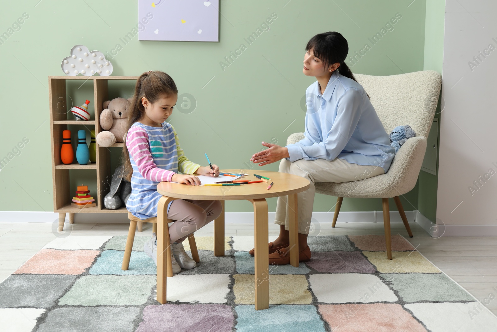 Photo of Little girl drawing during psychological evaluation in office