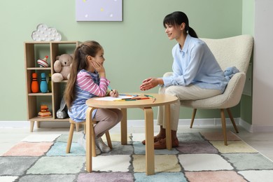 Photo of Little girl drawing during psychological evaluation in office