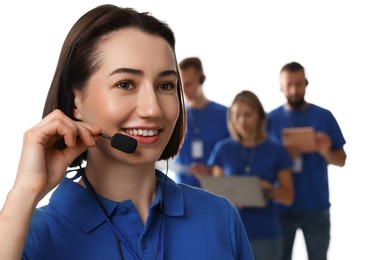 Photo of Technical support call center. Smiling operator on white background, selective focus