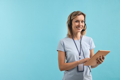 Technical support call center. Smiling operator with tablet on light blue background. Space for text