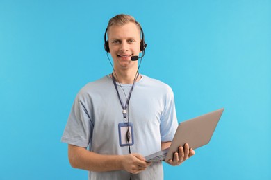 Photo of Technical support call center. Smiling operator with laptop on light blue background