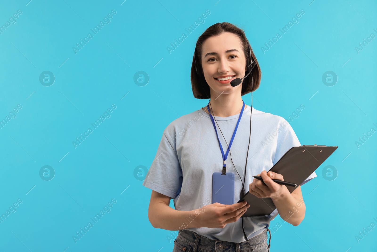 Photo of Technical support call center. Smiling operator with clipboard on light blue background. Space for text