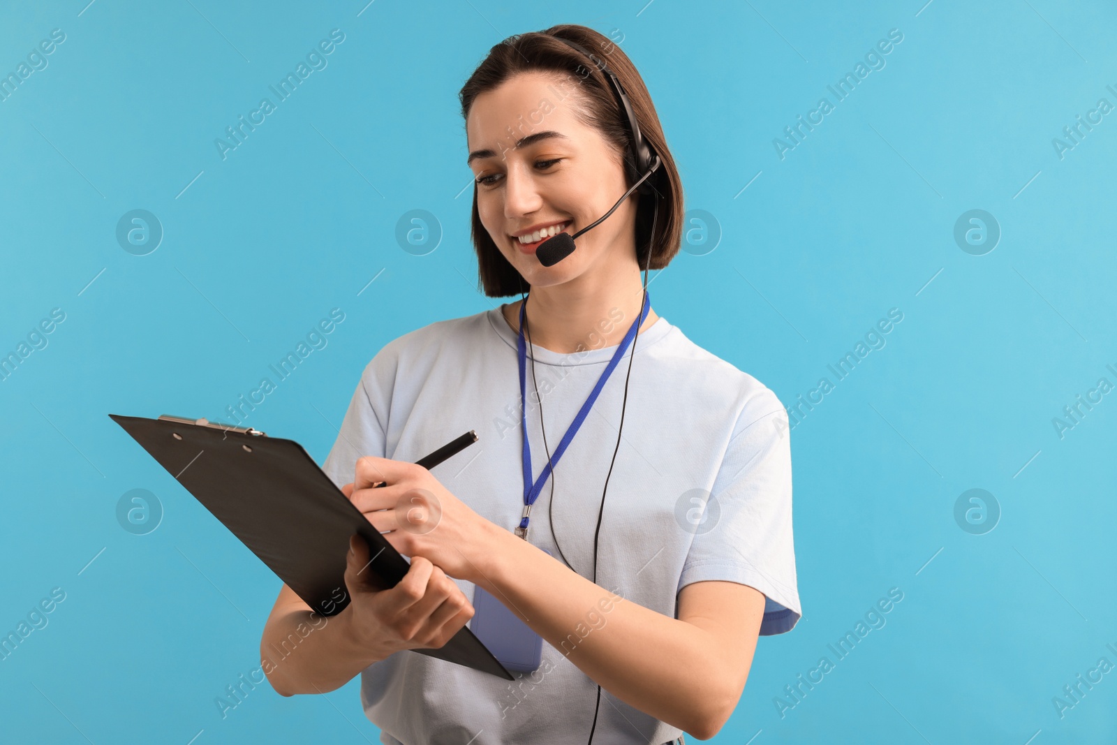 Photo of Technical support call center. Smiling operator with clipboard on light blue background