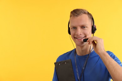 Technical support call center. Smiling operator with clipboard on yellow background. Space for text