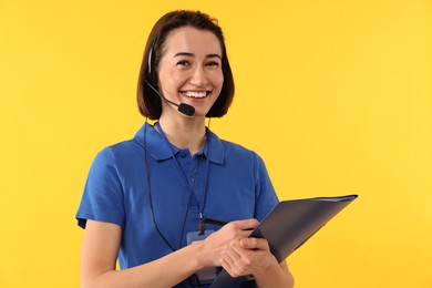 Photo of Technical support call center. Smiling operator with folder on yellow background