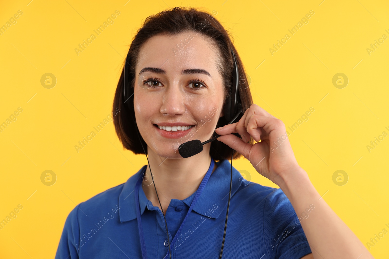 Photo of Technical support call center. Portrait of smiling operator on yellow background