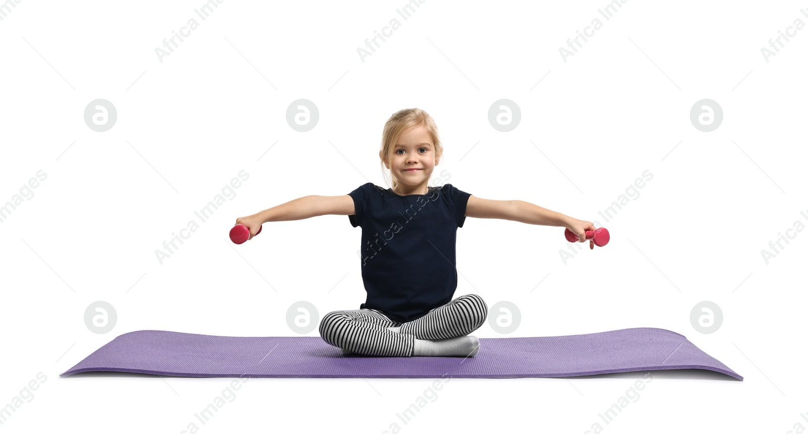 Photo of Little girl exercising with dumbbells on fitness mat against white background. Sport activity