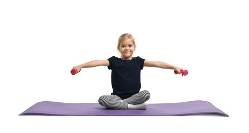 Little girl exercising with dumbbells on fitness mat against white background. Sport activity