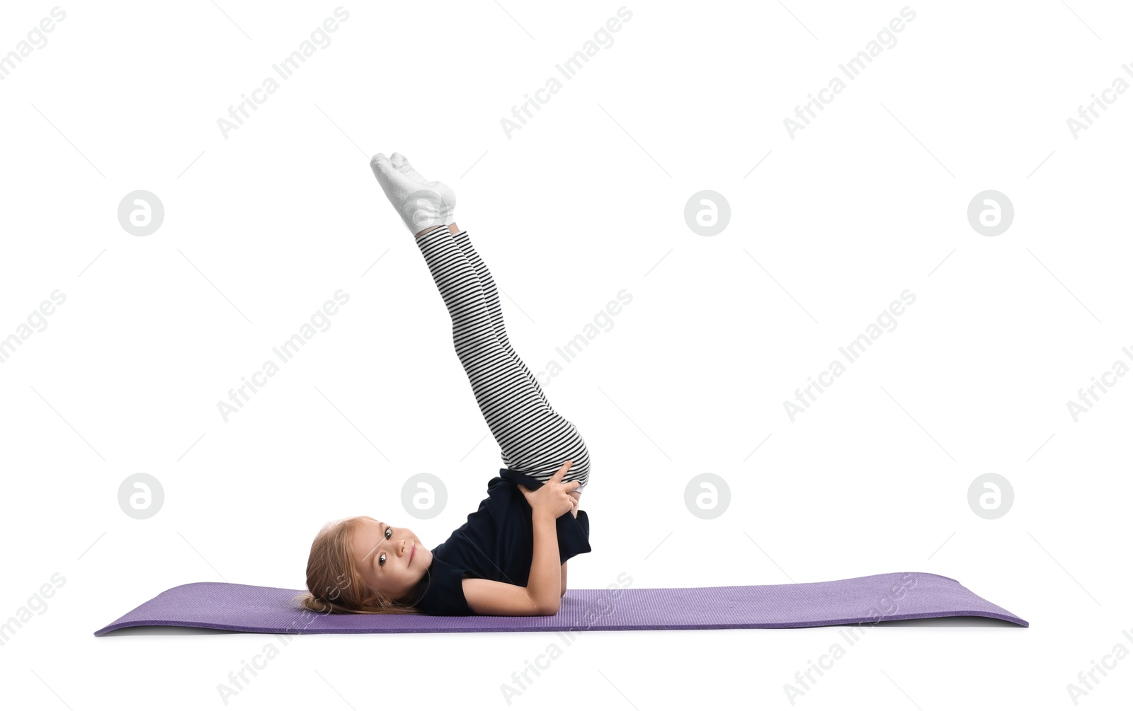 Photo of Little girl exercising on fitness mat against white background. Sport activity