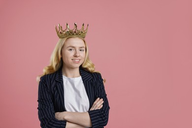 Smiling businesswoman in elegant crown on dusty pink background. Space for text