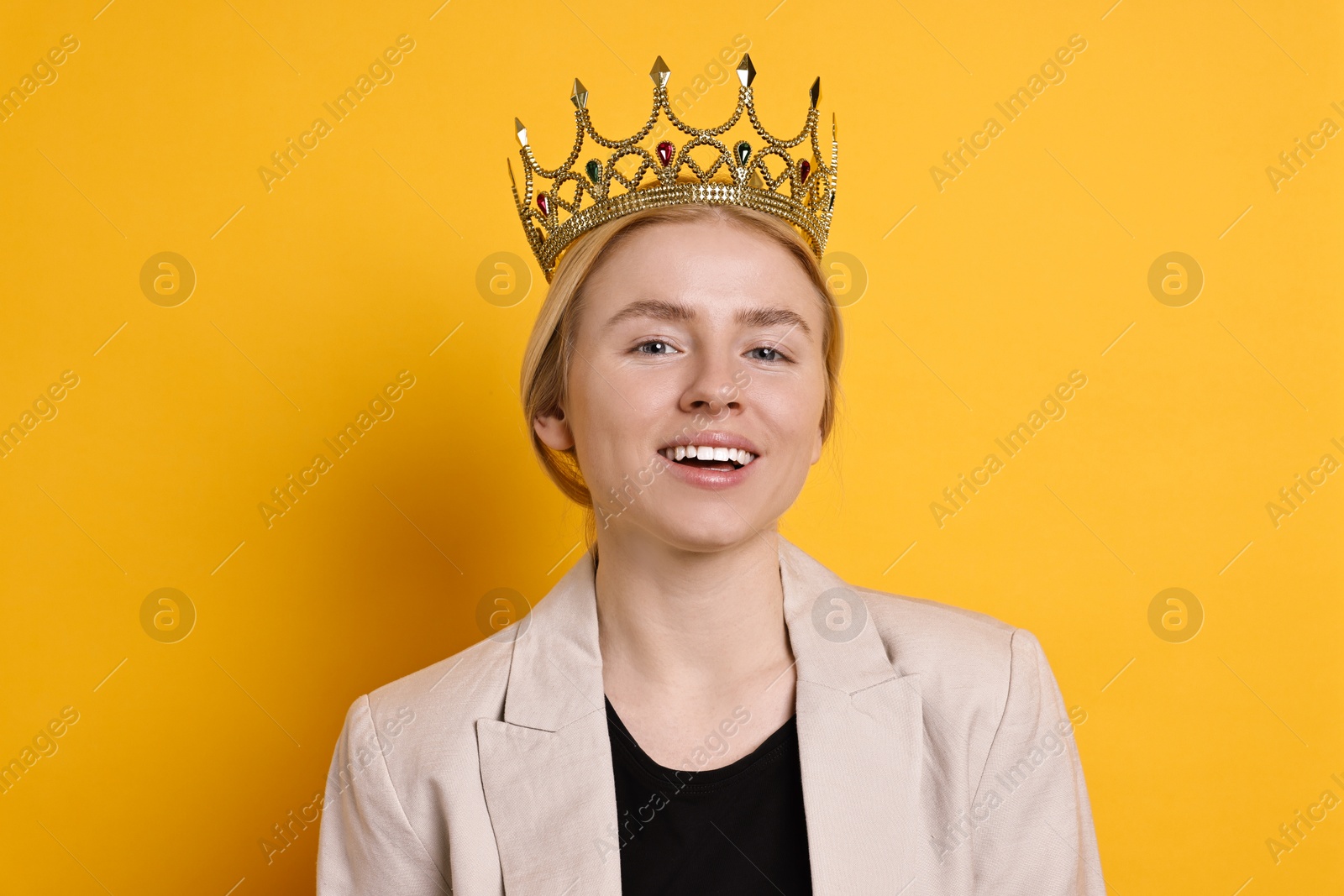 Photo of Smiling businesswoman in elegant crown on yellow background