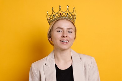 Smiling businesswoman in elegant crown on yellow background