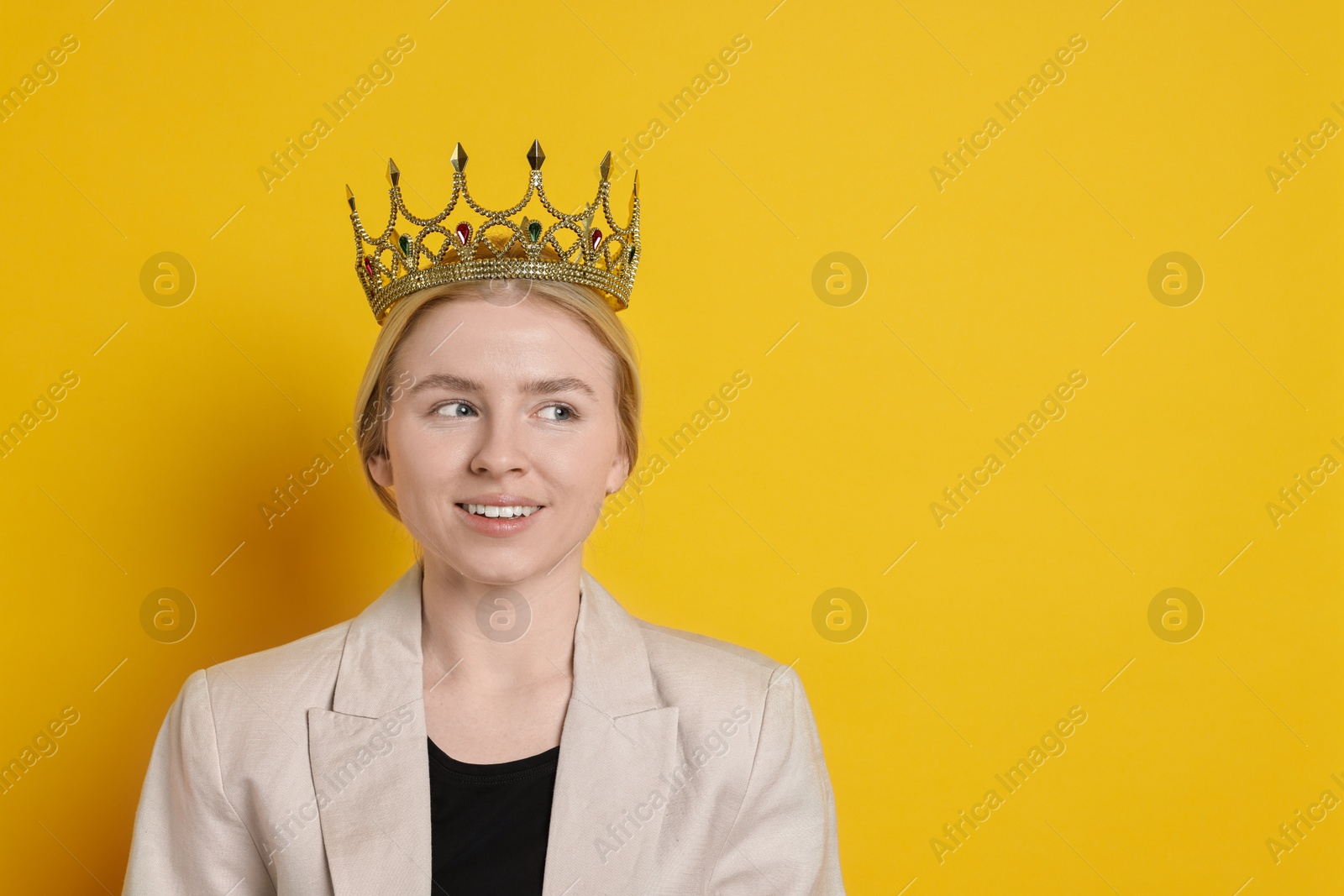 Photo of Smiling businesswoman in elegant crown on yellow background. Space for text