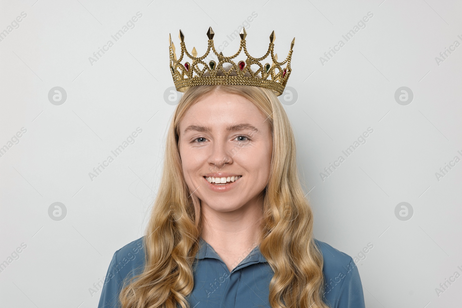 Photo of Smiling woman in elegant crown on light background