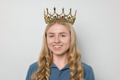 Smiling woman in elegant crown on light background