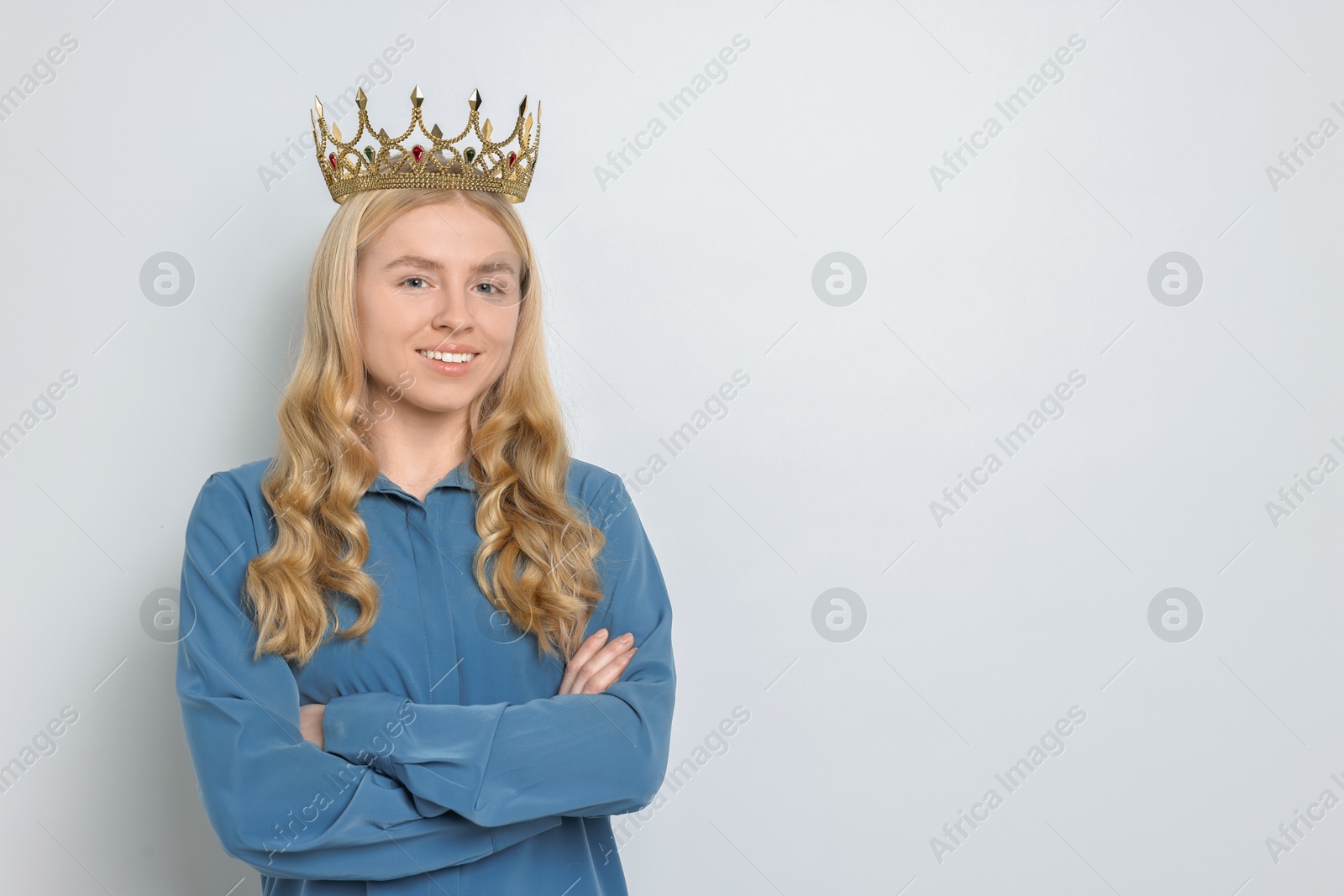 Photo of Smiling woman in elegant crown on light background. Space for text