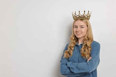 Smiling woman in elegant crown on light background. Space for text