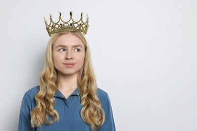 Woman in elegant crown on light background. Space for text