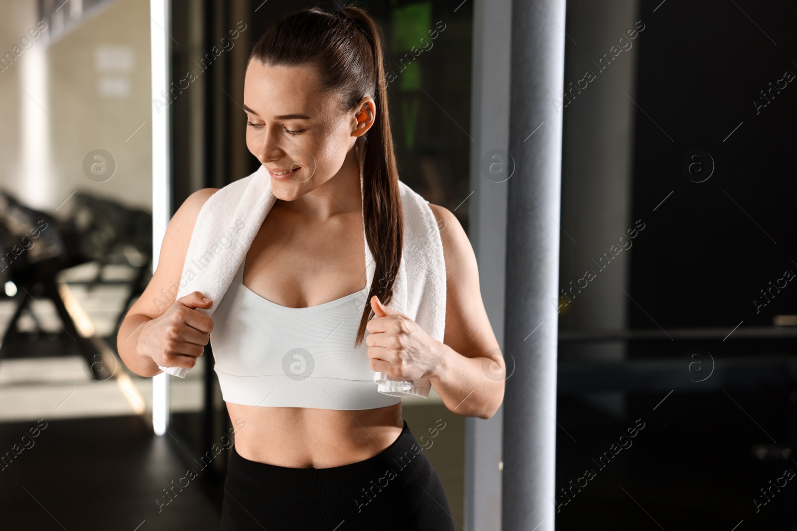 Photo of Happy woman with towel in fitness studio