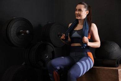 Happy woman with terry towel in gym