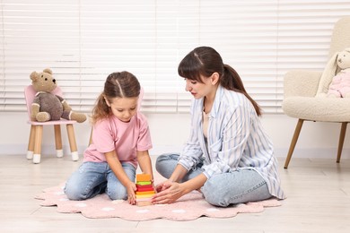 Photo of Autism therapy. Psychologist and little girl playing with educational toy in mental health center