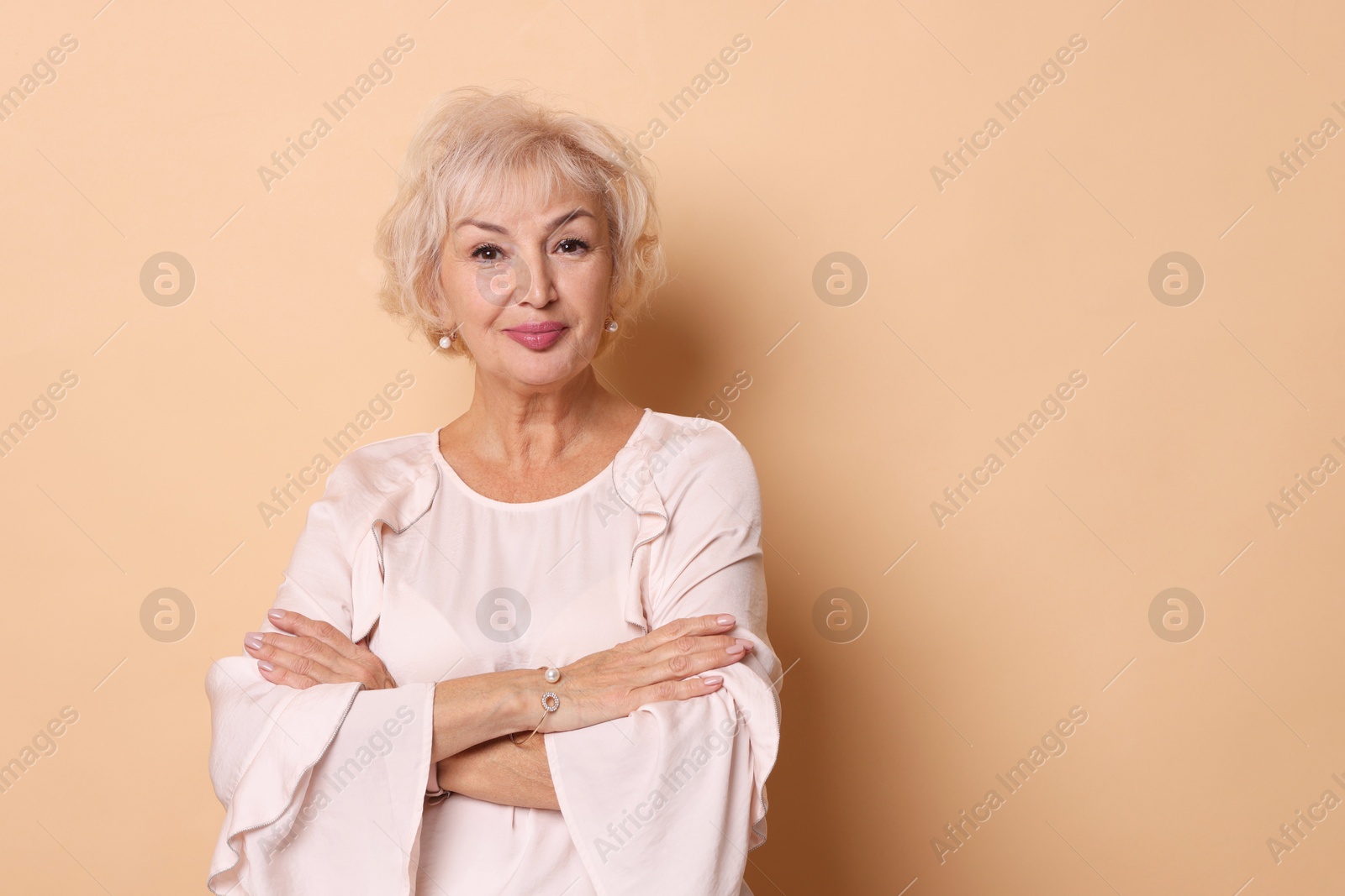 Photo of Portrait of elegant grandmother on beige background. Space for text