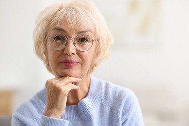 Portrait of grandmother in glasses at home. Space for text