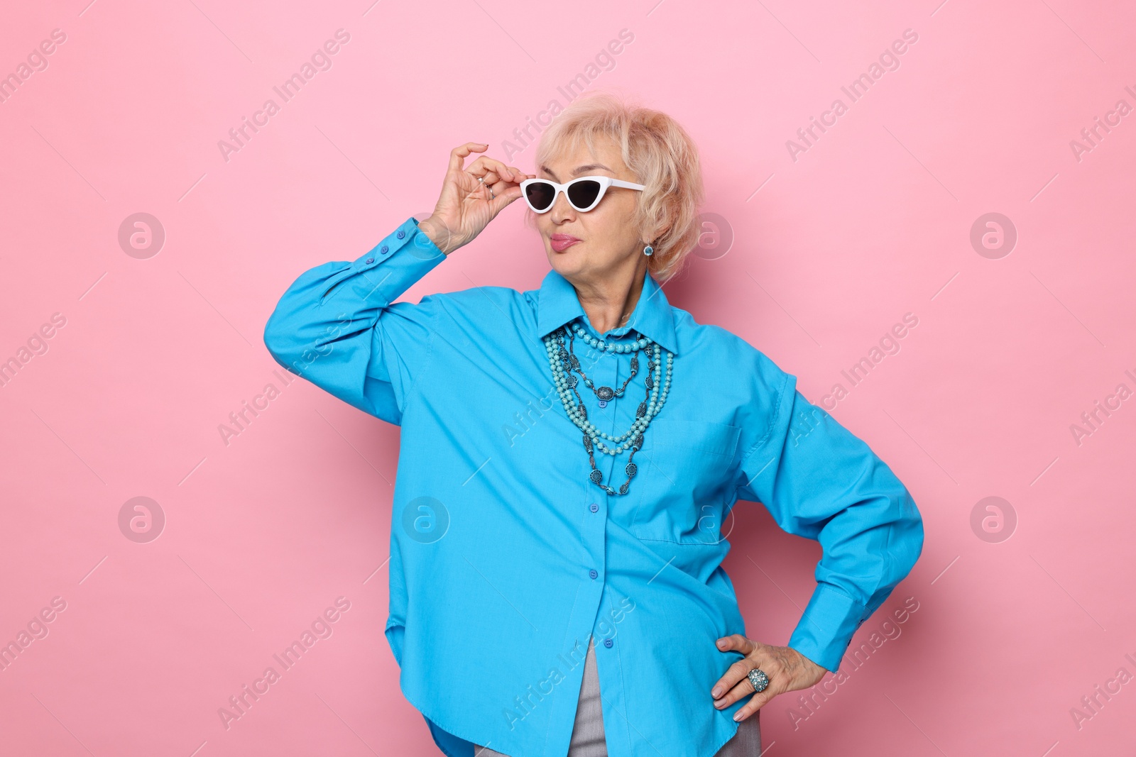 Photo of Portrait of cool grandmother on pink background