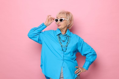 Portrait of cool grandmother on pink background