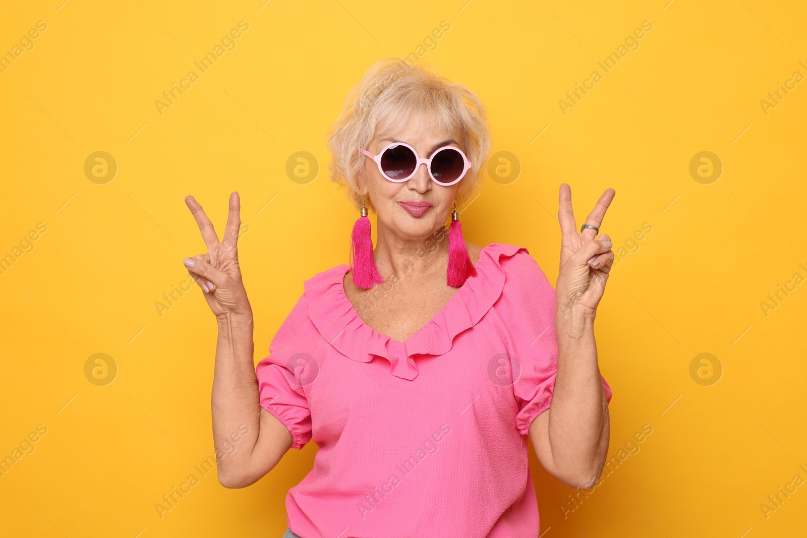 Photo of Portrait of cool grandmother on orange background