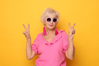 Portrait of cool grandmother on orange background