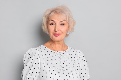 Portrait of elegant grandmother on light grey background