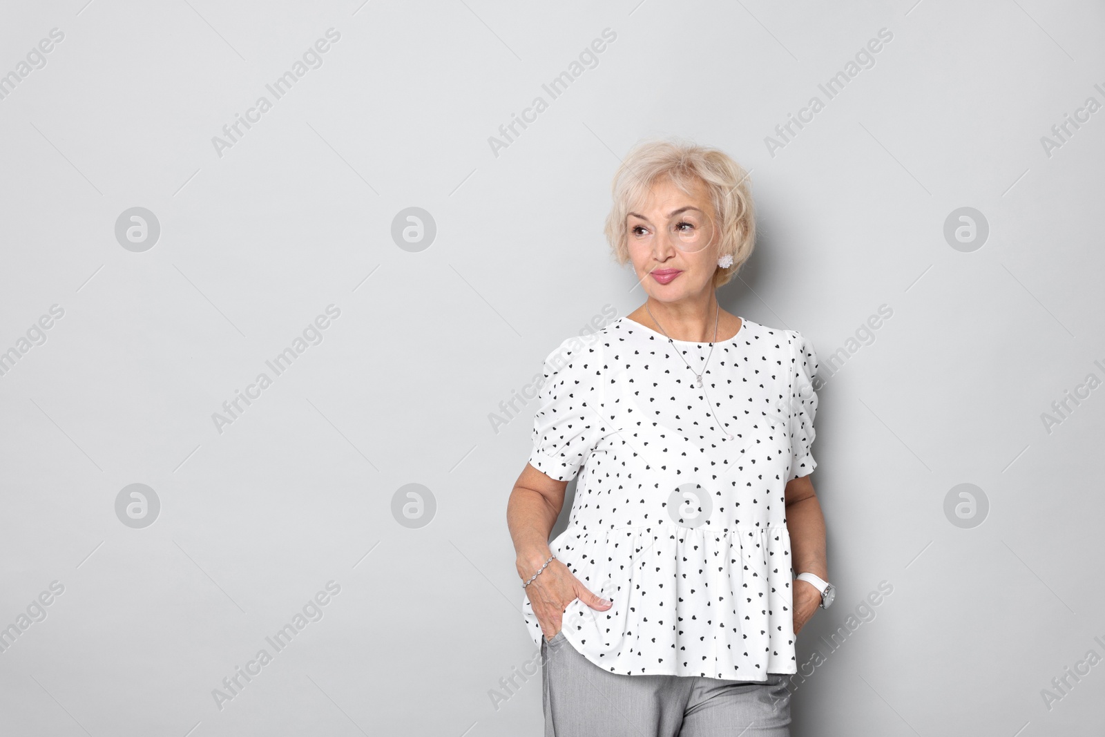 Photo of Portrait of grandmother on light grey background. Space for text