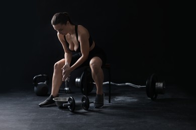 Photo of Woman applying talcum powder onto hands before training on black background