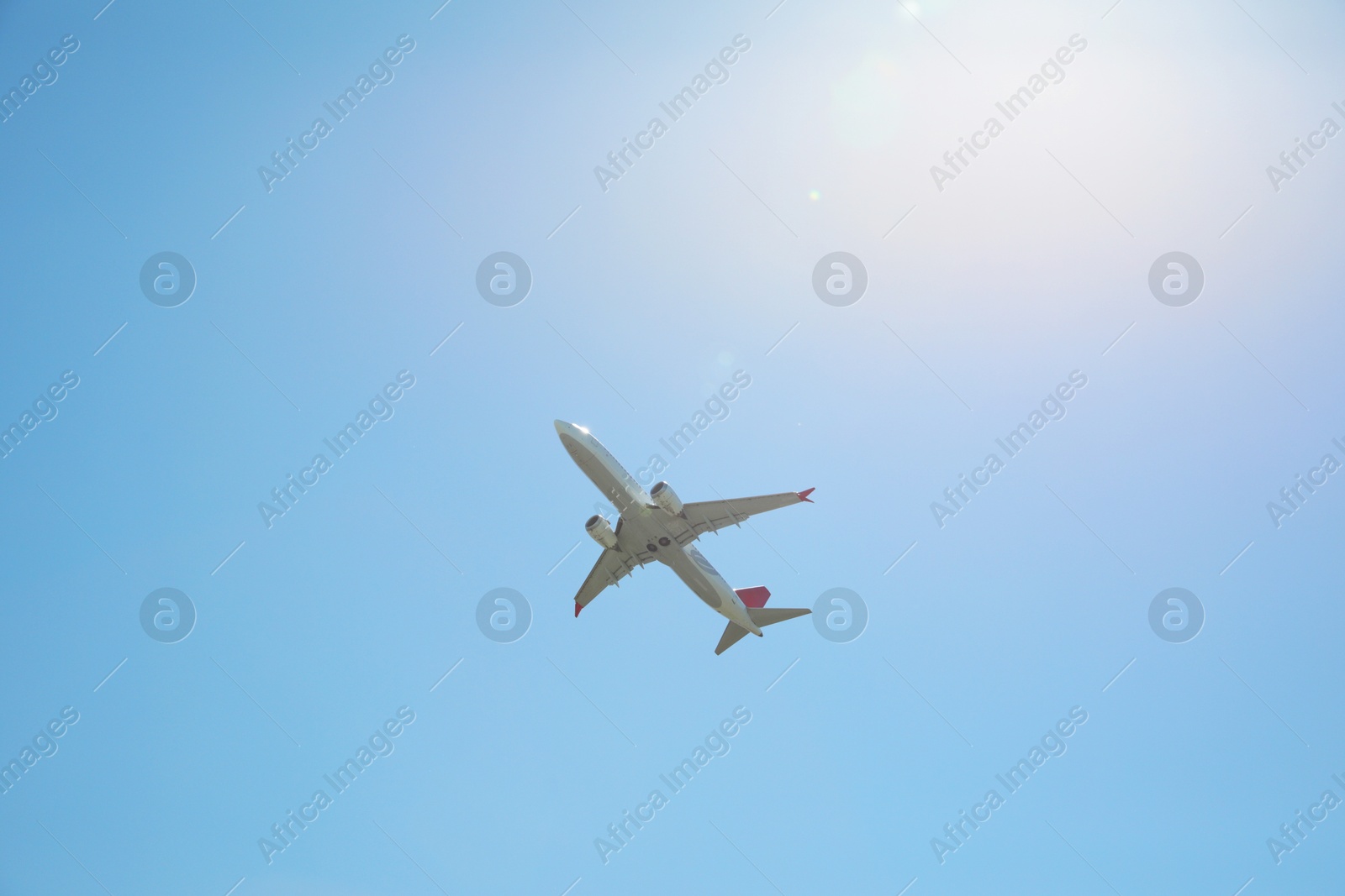 Photo of Modern white airplane flying in sky, low angle view