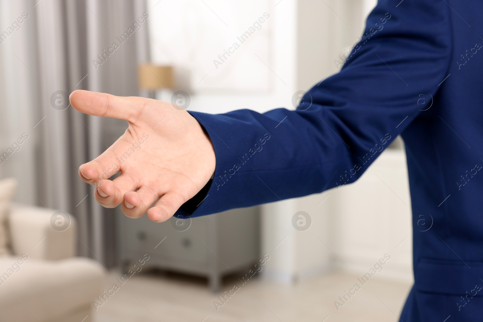 Photo of Offering help. Man reaching his hand indoors, closeup