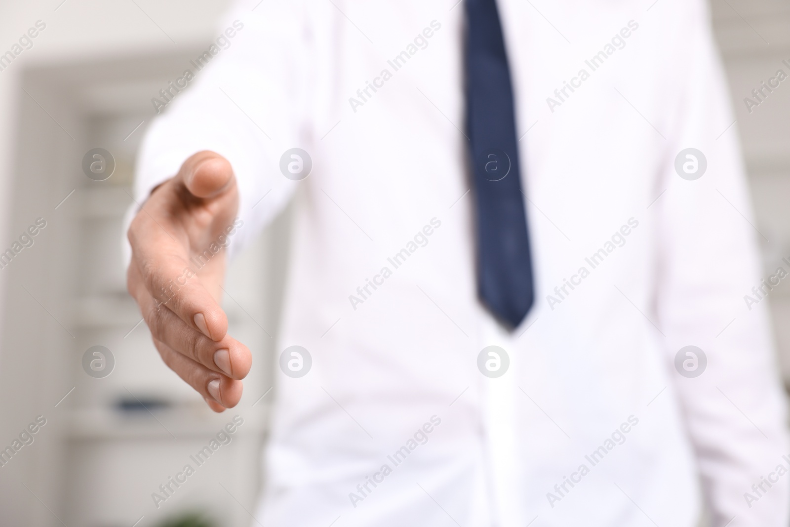 Photo of Offering help. Man reaching his hand indoors, closeup