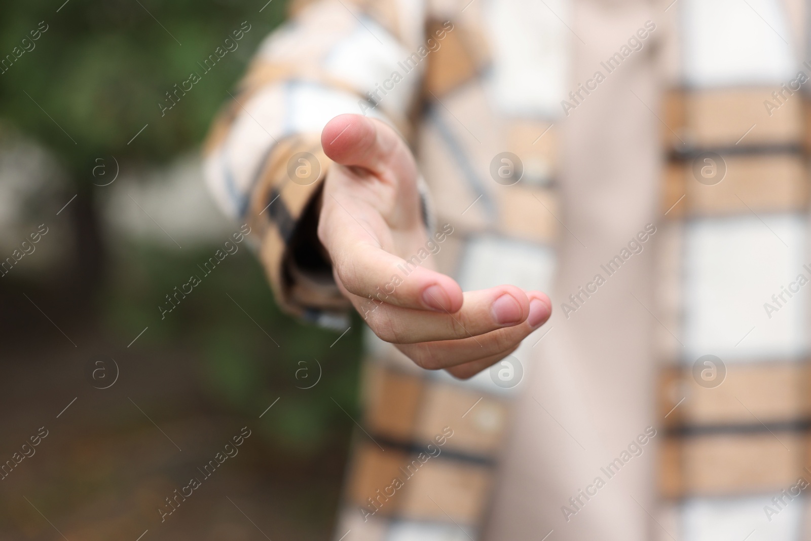 Photo of Offering help. Man reaching his hand outdoors, closeup