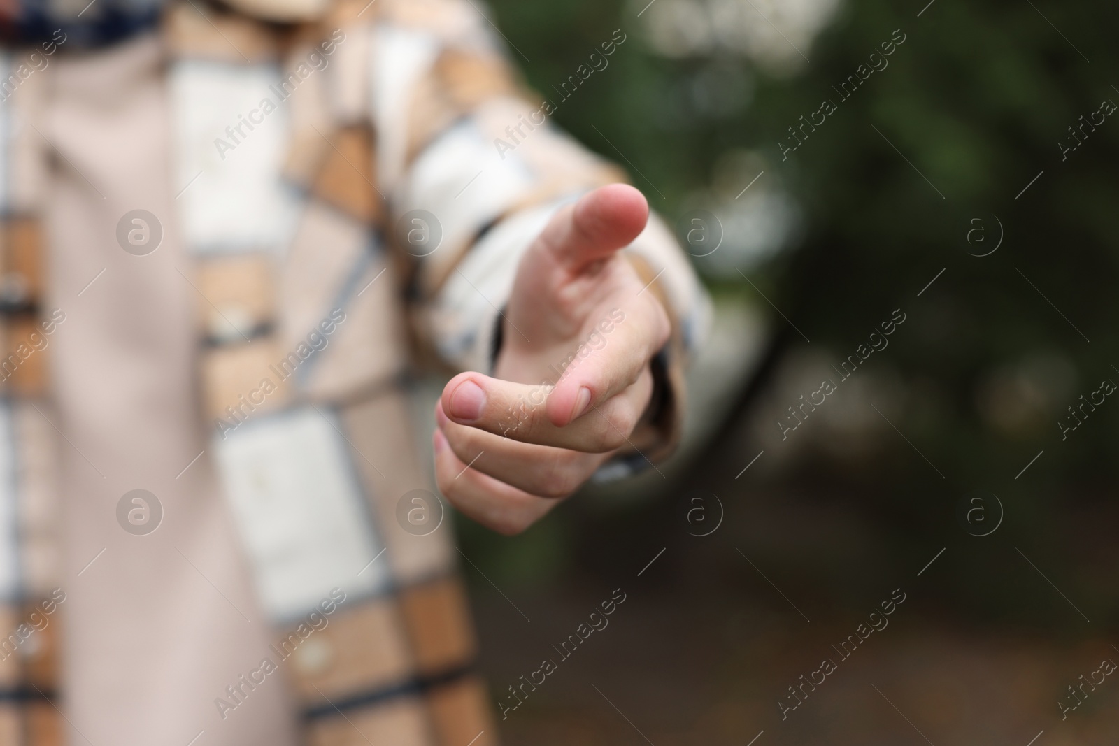 Photo of Offering help. Man reaching his hand outdoors, closeup