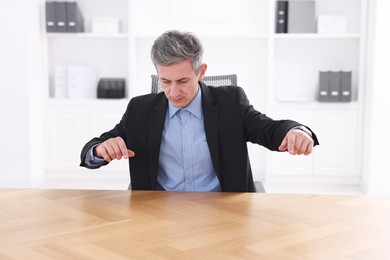 Photo of Man showing something at desk in office