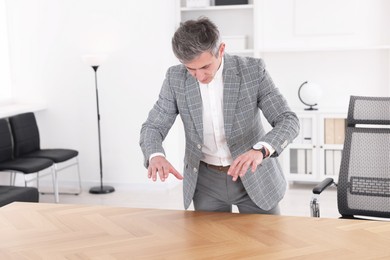 Photo of Man showing something at desk in office