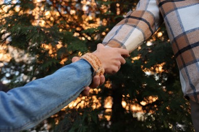 Photo of Help and support. People holding hands outdoors, closeup