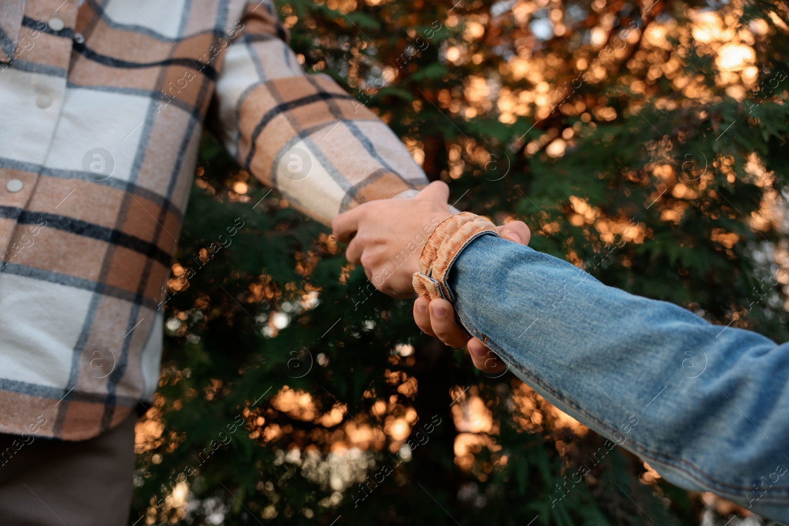 Photo of Help and support. People holding hands outdoors, closeup