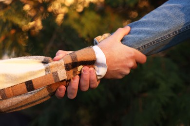 Photo of Help and support. People holding hands outdoors, closeup