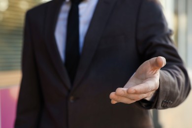 Photo of Man offering helping hand on city street, closeup