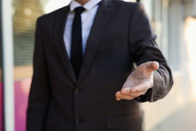 Photo of Man offering helping hand on city street, closeup