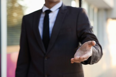 Photo of Man offering helping hand on city street, closeup