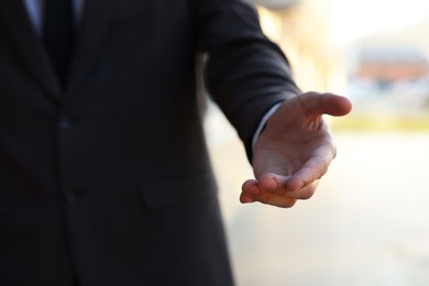 Photo of Man offering helping hand on city street, closeup