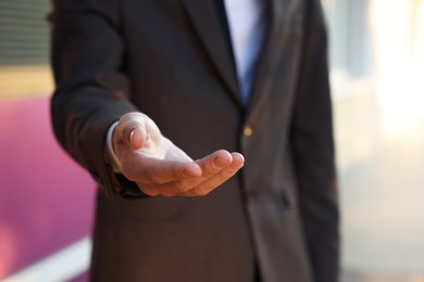 Photo of Man offering helping hand on city street, closeup