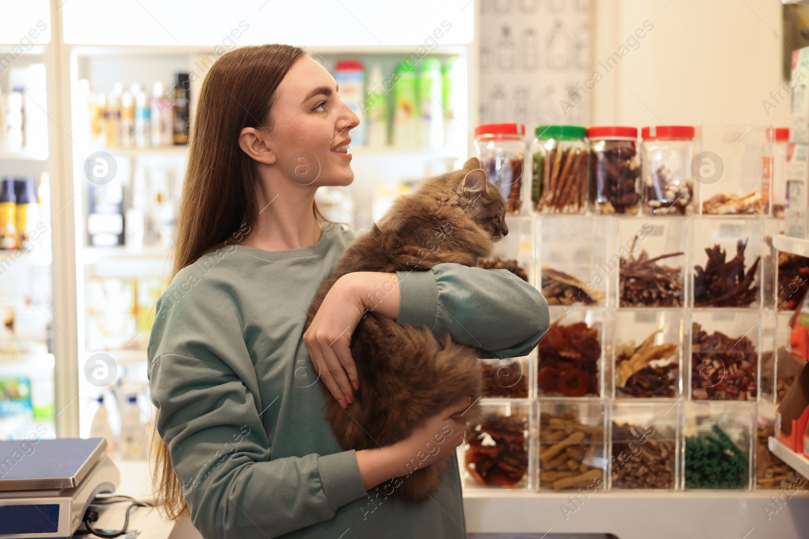 Photo of Woman with her cute cat in pet shop